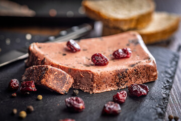 Liver pate with cranberries on stone cutting board.