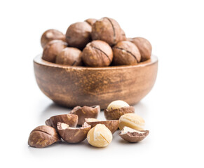 Tasty macadamia nuts in bowl isolated on white background.