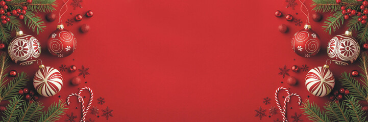 Festive Christmas ornaments and candy canes on red background create a joyful holiday atmosphere perfect for seasonal greetings and advertising campaigns