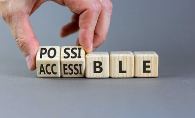 Accessible or possible symbol. Concept words Accessible or Possible on beautiful wooden blocks. Beautiful grey background. Doctor's hand. Business accessible or possible concept. Copy space.