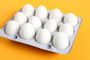 Holder with fresh boiled quail eggs on orange background