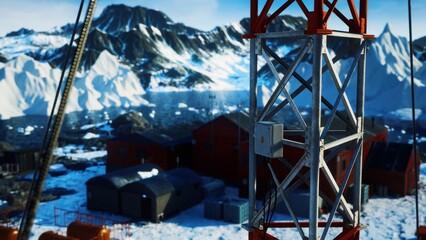 A stunning view of a research station nestled among towering mountains and glistening ice.