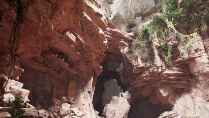 Breathtaking rock formations rise dramatically within a stunning canyon, adorned with lush greenery. Sunlight filters through the crevices, illuminating the rugged textures around.