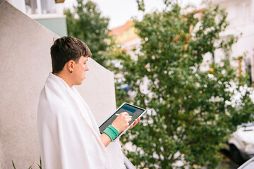 Obraz premium Individual wrapped in cloth views metropolis from high balcony