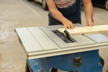 A young craftsman restores a caravan in a hangar.