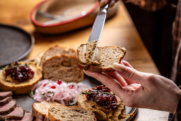 Smearing savory pate on rustic bread slice