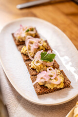 Rye bread bites with creamy spread and pickled onions