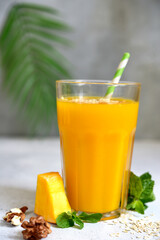 Pumpkin smoothie with apple,oat and nuts for a breakfast in a tall glass.