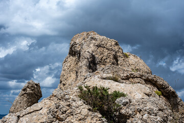Majestic rocky cliff under dramatic cloudy sky capturing nature's raw beauty