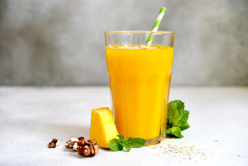 Pumpkin smoothie with apple,oat and nuts for a breakfast in a tall glass.