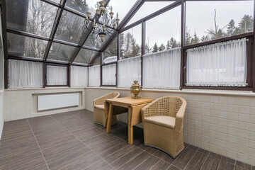 Bright and spacious sunroom with a wooden table and chairs in a cozy setting