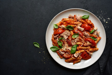 Pasta penne with tomatoes and tuna. Top view with copy space.