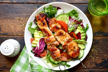 Chicken kebab skewers with vegetable salad. Top view with copy space.
