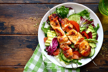 Chicken kebab skewers with vegetable salad. Top view with copy space.