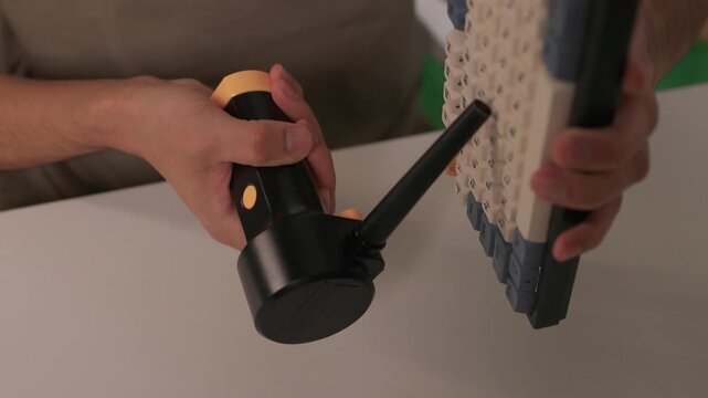 Closeup showing detailed cleaning of keyboard keys, Demonstration of meticulous keyboard cleaning involving dust removal and careful inspection in home environment