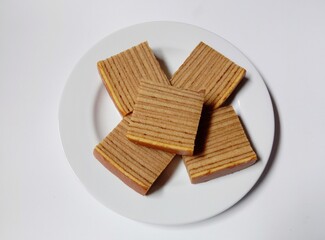 close-up of indonesian layer cake lapis legit slices on white plate.
