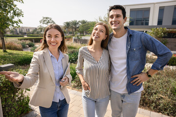 Real estate agent showing garden view to smiling couple