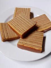 close-up of indonesian layer cake lapis legit slices on white plate.