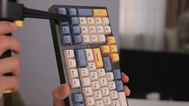 Closeup showing detailed cleaning of keyboard keys, Demonstration of meticulous keyboard cleaning involving dust removal and careful inspection in home environment
