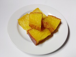 slice of bika ambon cake. close-up bika ambon indonesian traditional honeycomb cake on white plate.