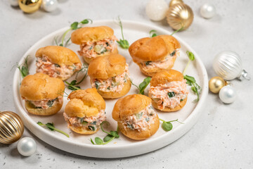 Smoked Salmon Cream Puffs served on a round plate with festive decorations