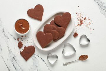Bowl with sweet chocolate heart-shaped cookies on white background. Valentine's Day celebration