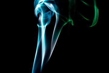 Blue And Green Smoke Trails On Black Background For Abstract Art And Creative Design Use. Long Exposure Experiment