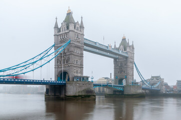 Obraz premium Tower Bridge London In Fog Over River Thames Highlighting Historic Architecture And Urban Waterfront