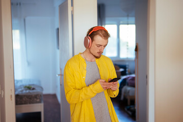 Person with red headphones looks at messages and reminders on phone