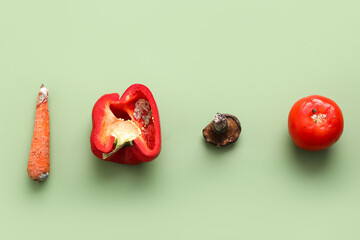Moldy vegetables and mushroom on green background