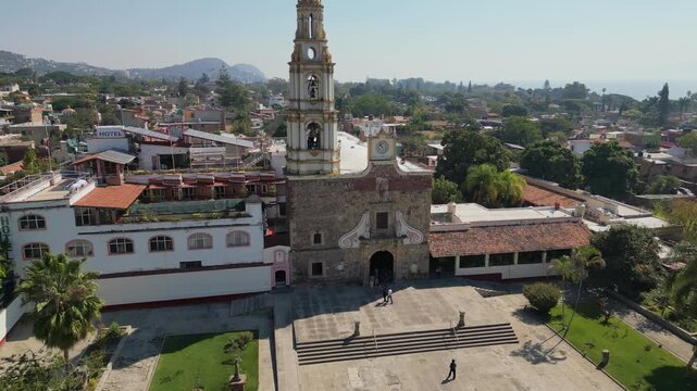 Drone aerial retreat shot moving away from the Parish of Saint Andrew the Apostle in the town center of Ajijic Jalisco Mexico