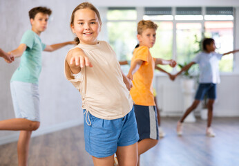 In fitness club, boy became couple with girl and trains dance to rhythm of Latin music. Classes for children workout in mini group gym