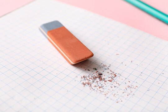 Notebook with eraser on pink background