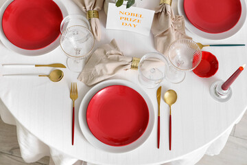 Elegant table setting for Nobel prize day with golden cutlery in dining room