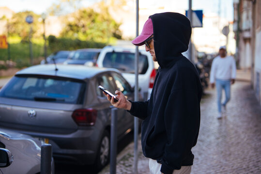 Young adult wearing casual clothing interacting with mobile device outdoors