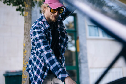 Casual repair scene of man fixing bicycle in quiet city space