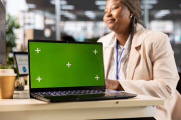African american project manager working at desk next to copy space display, using performance metrics in order to review organizational success. Female analyst at workstation.