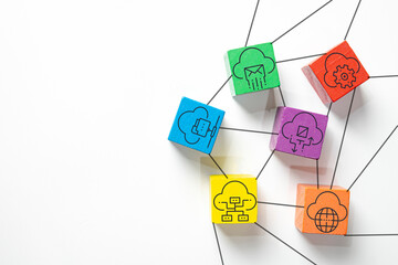 Colorful wooden blocks with cloud computing icons connected by lines, representing data storage, global network technology, and digital communication concept on white background with copyspace.