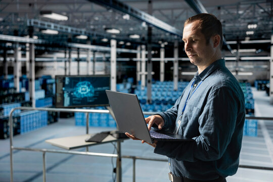Server hub computer scientist debugging machine learning scripts on laptop, doing AI automatization. Data center worker optimizing neural networks, adjusting artificial intelligence models
