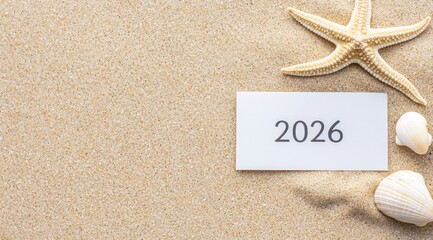 Sand beach presenting 2026 year on a white card, decorated with a starfish and seashells, offering copy space