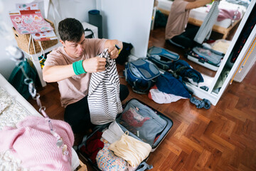 Asian learner carefully packs for overseas semester trip