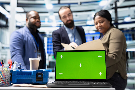 Professionals engineering group reviews solar panels next to chroma key, showcasing unity in green technology and eco friendly renewable energy. Operational leadership in manufacturing industry.