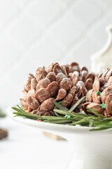 Christmas pine cones cakes close up, sweet and tasty holiday Christmas and New Year homemade dessert on white tile kitchen table