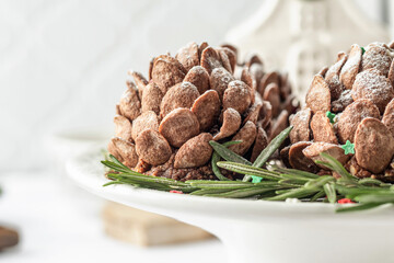 Christmas pine cones cakes close up, sweet and tasty holiday Christmas and New Year homemade dessert on white tile kitchen table