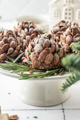 Christmas pine cones cakes close up, sweet and tasty holiday Christmas and New Year homemade dessert on white tile kitchen table