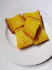 slice of bika ambon cake. close-up bika ambon indonesian traditional honeycomb cake on white plate.