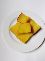 slice of bika ambon cake. close-up bika ambon indonesian traditional honeycomb cake on white plate.