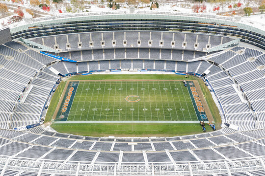 Chicago, IL, USA - November 11, 2025: An aerial view of Soldier Field, home to the Chicago Bears, looking towards the Chicago skyline in the fall with snow on the ground.
