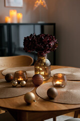 Cozy home atmosphere. Christmas lights and decoration on wooden table in nordic interior.