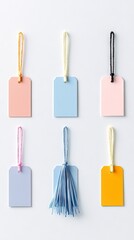 Naklejka premium Overhead shot of six colorful price tags with strings, arranged on a white surface. The tags are in various pastel colors.